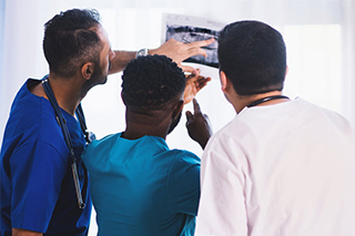 Three doctors discussing the x-ray