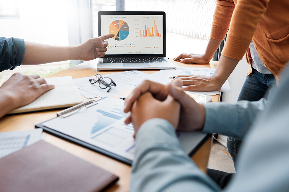 Marketingteam in einem Meeting, in dem Marketingdatenanalysen und eine Grafik zu Marketinglösungen von Minitab besprochen werden.