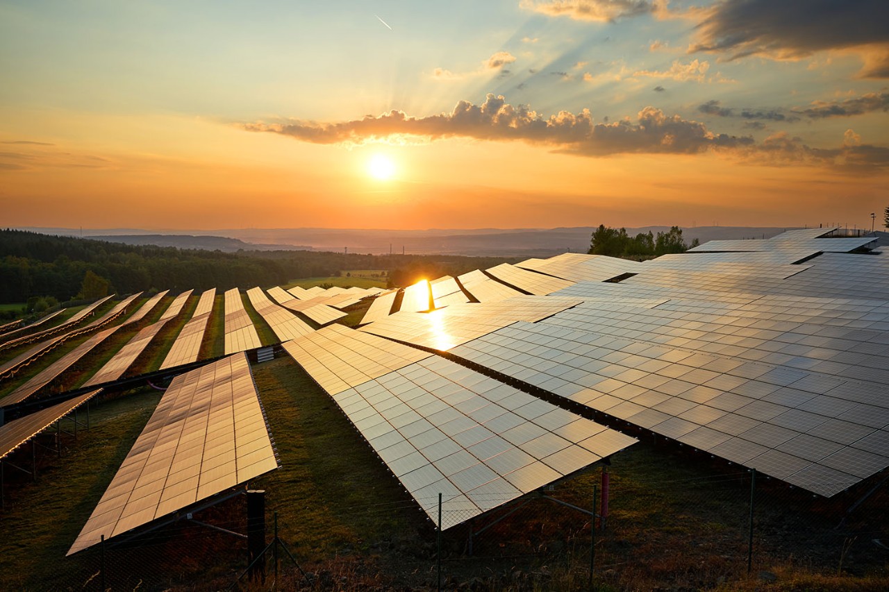 Photovoltaic panels of solar power station in the landscape at sunset. View from above.
