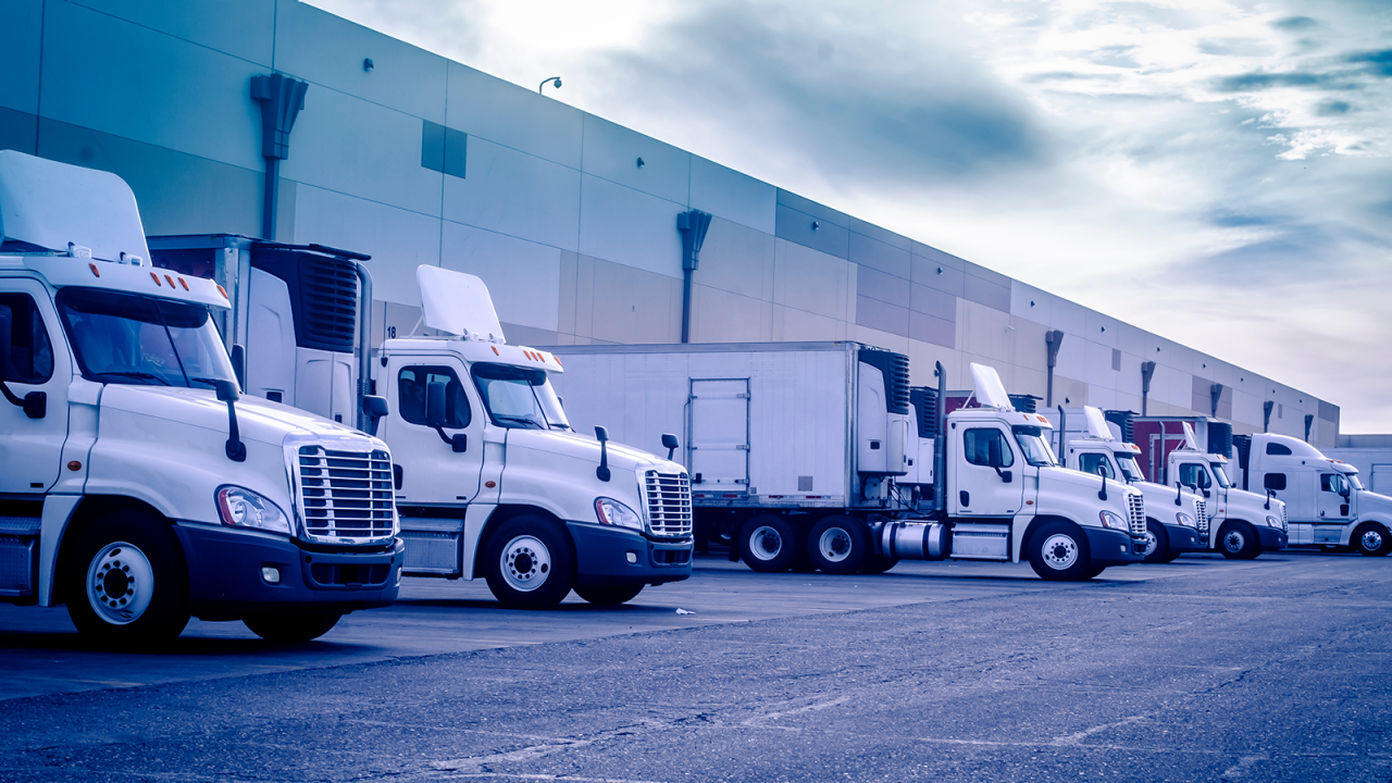 Eighteen wheelers loading and unloading at a warehouse.